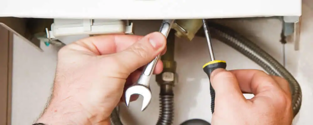 Boiler repair technician tightening pipe fittings and connections in Louisville, KY