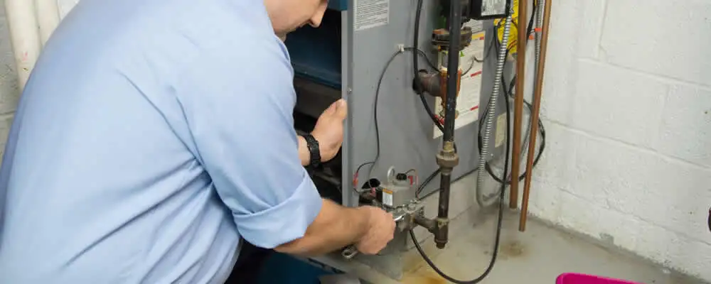 Furnace repair technician inspecting and servicing a home heating system in Louisville, KY