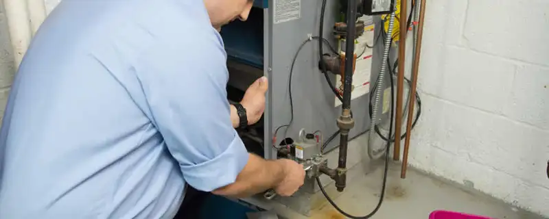 Furnace repair technician inspecting and servicing a home heating system in Louisville, KY