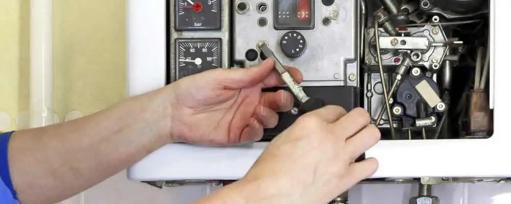 Heating repair technician adjusting boiler controls and components in Louisville, KY
