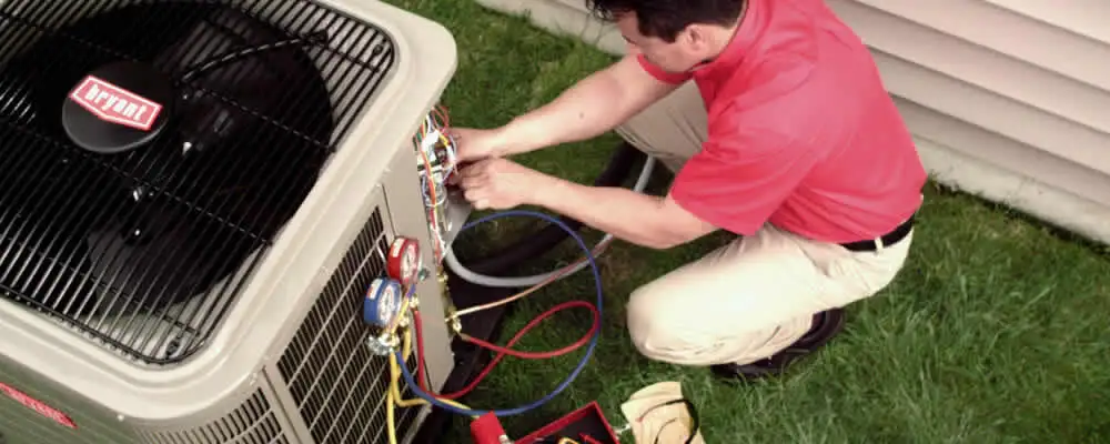 HVAC technician servicing an outdoor air conditioner unit in Louisville, KY