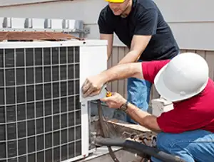 HVAC technicians repairing an outdoor AC unit on a rooftop in Louisville, KY