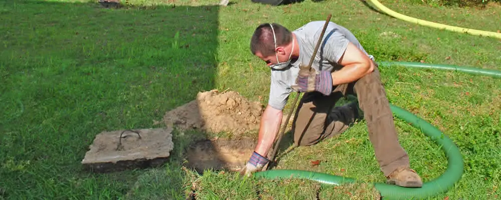 Septic pumping technician servicing a residential septic tank in Louisville, KY