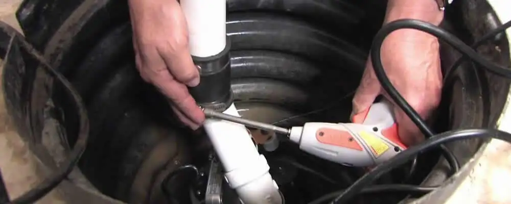 Sump pump installation technician connecting PVC discharge piping in Louisville, KY