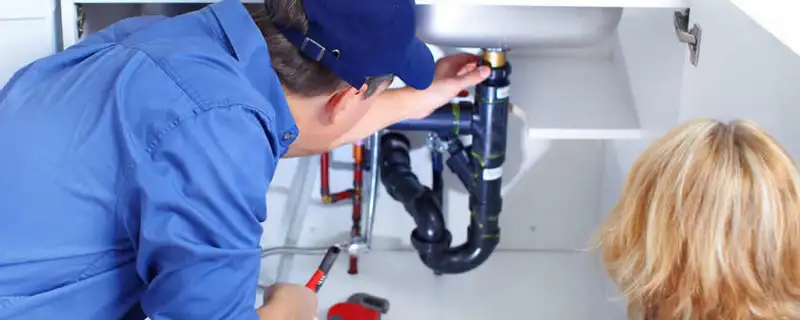 Plumber repairing under-sink drain pipes and fittings in Louisville, KY